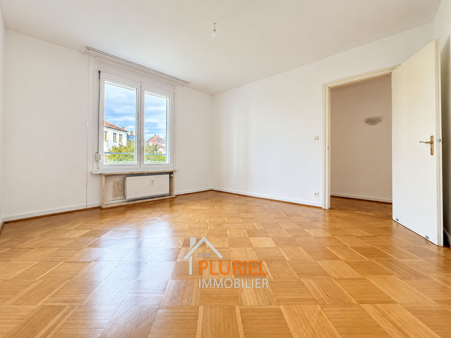 Pièce lumineuse avec parquet et fenêtre