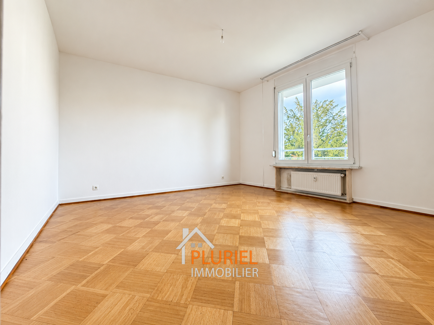Pièce vide lumineuse au parquet chaleureux