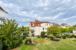 Villa élégante au jardin paysager sous ciel nuageux