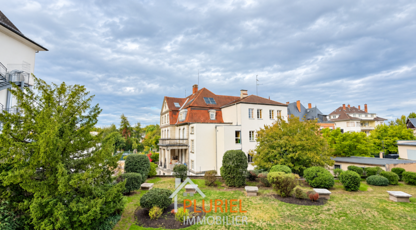 Villa élégante au jardin paysager sous ciel nuageux