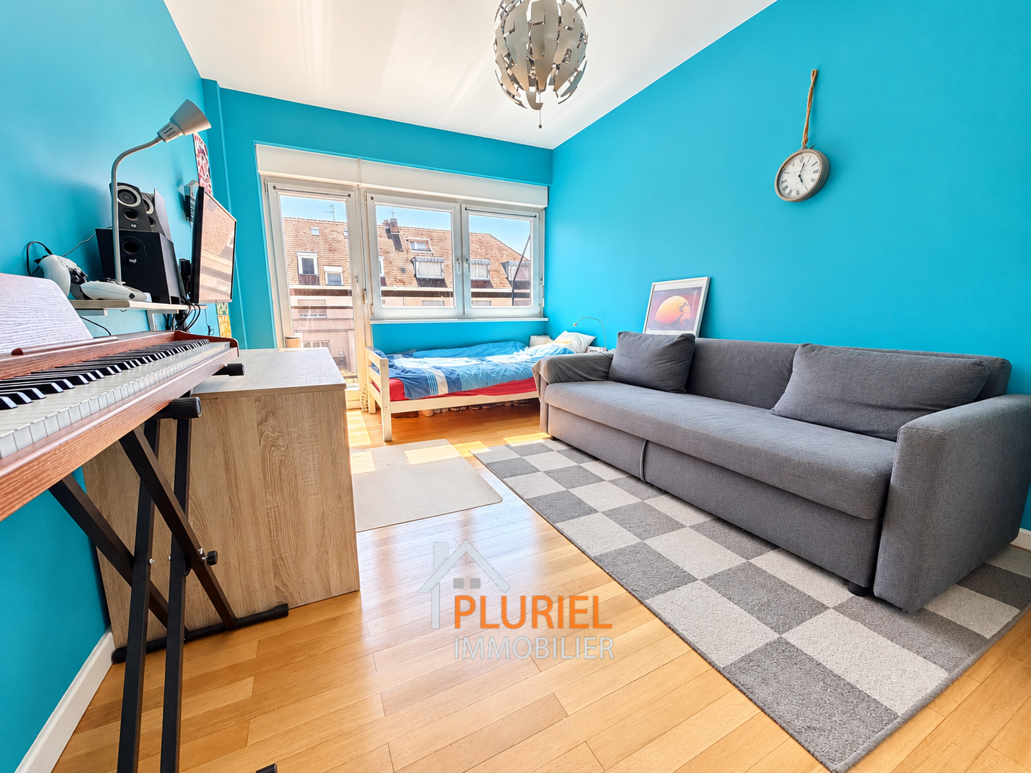 Chambre studio lumineuse avec piano et canapé
