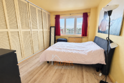 Chambre lumineuse avec vue urbaine