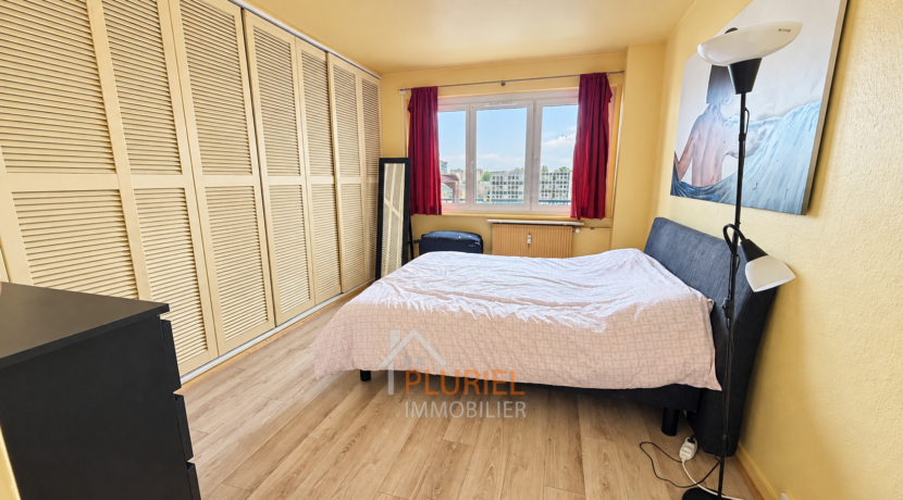 Chambre lumineuse avec vue urbaine