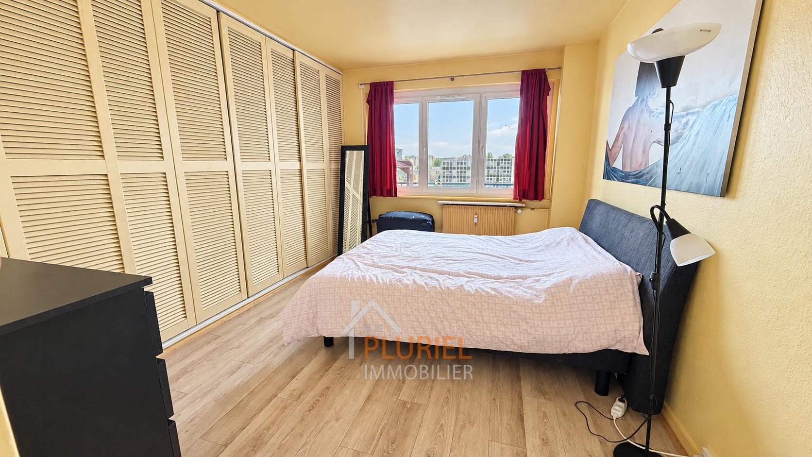 Chambre lumineuse avec vue urbaine