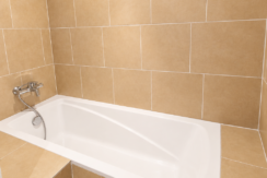 Baignoire blanche dans salle de bain beige