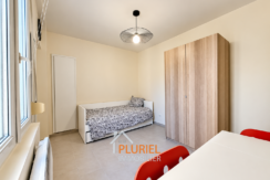 Chambre minimaliste lumineuse avec mobilier rouge