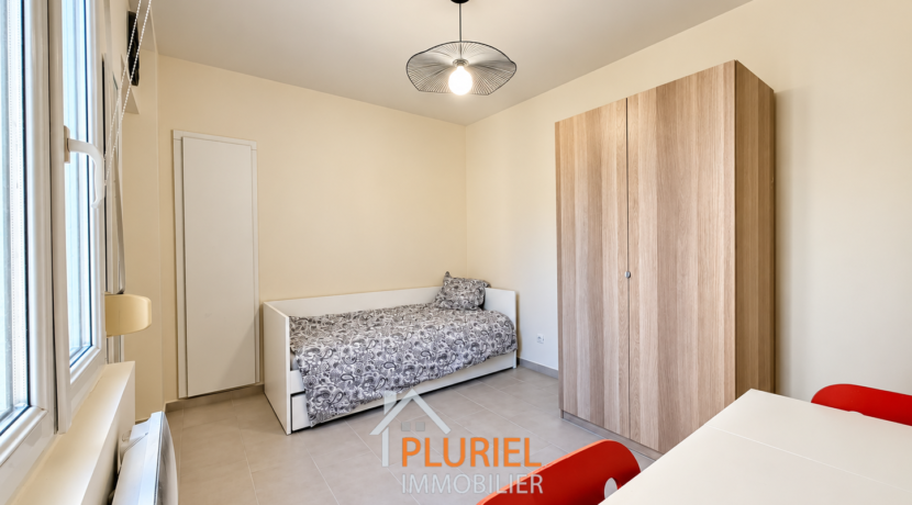 Chambre minimaliste lumineuse avec mobilier rouge
