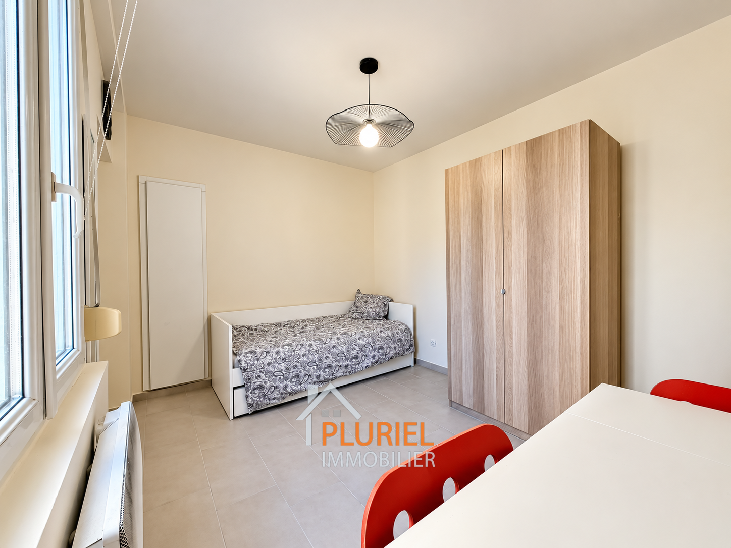 Chambre minimaliste lumineuse avec mobilier rouge