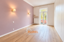 Chambre moderne mauve avec balcon verdoyant