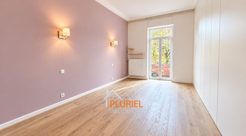 Chambre moderne mauve avec balcon verdoyant