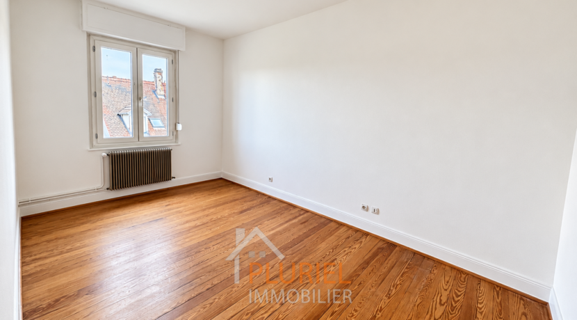 Chambre vide lumineuse au parquet chaleureux