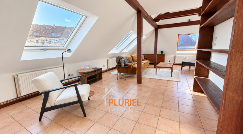 Loft mansardé lumineux aux poutres apparentes