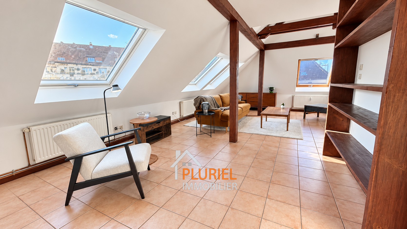 Loft mansardé lumineux aux poutres apparentes