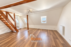 Loft mansardé lumineux aux poutres apparentes
