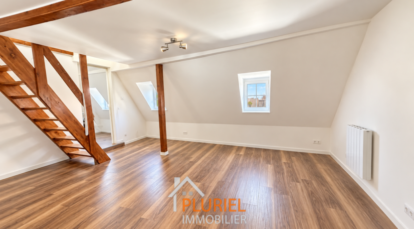 Loft mansardé lumineux aux poutres apparentes