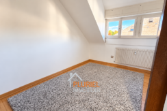 Pièce mansardée lumineuse avec tapis gris