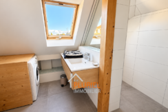 Salle de bains mansardée avec buanderie lumineuse