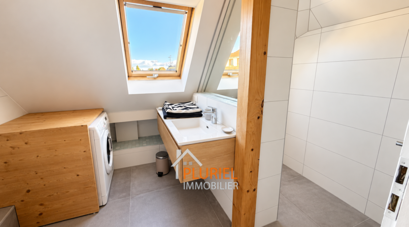 Salle de bains mansardée avec buanderie lumineuse