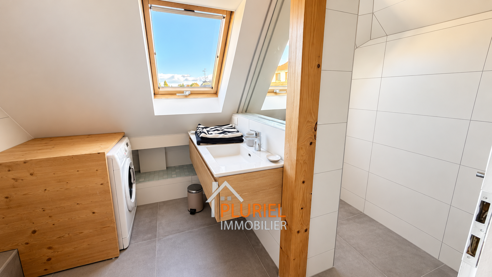 Salle de bains mansardée avec buanderie lumineuse