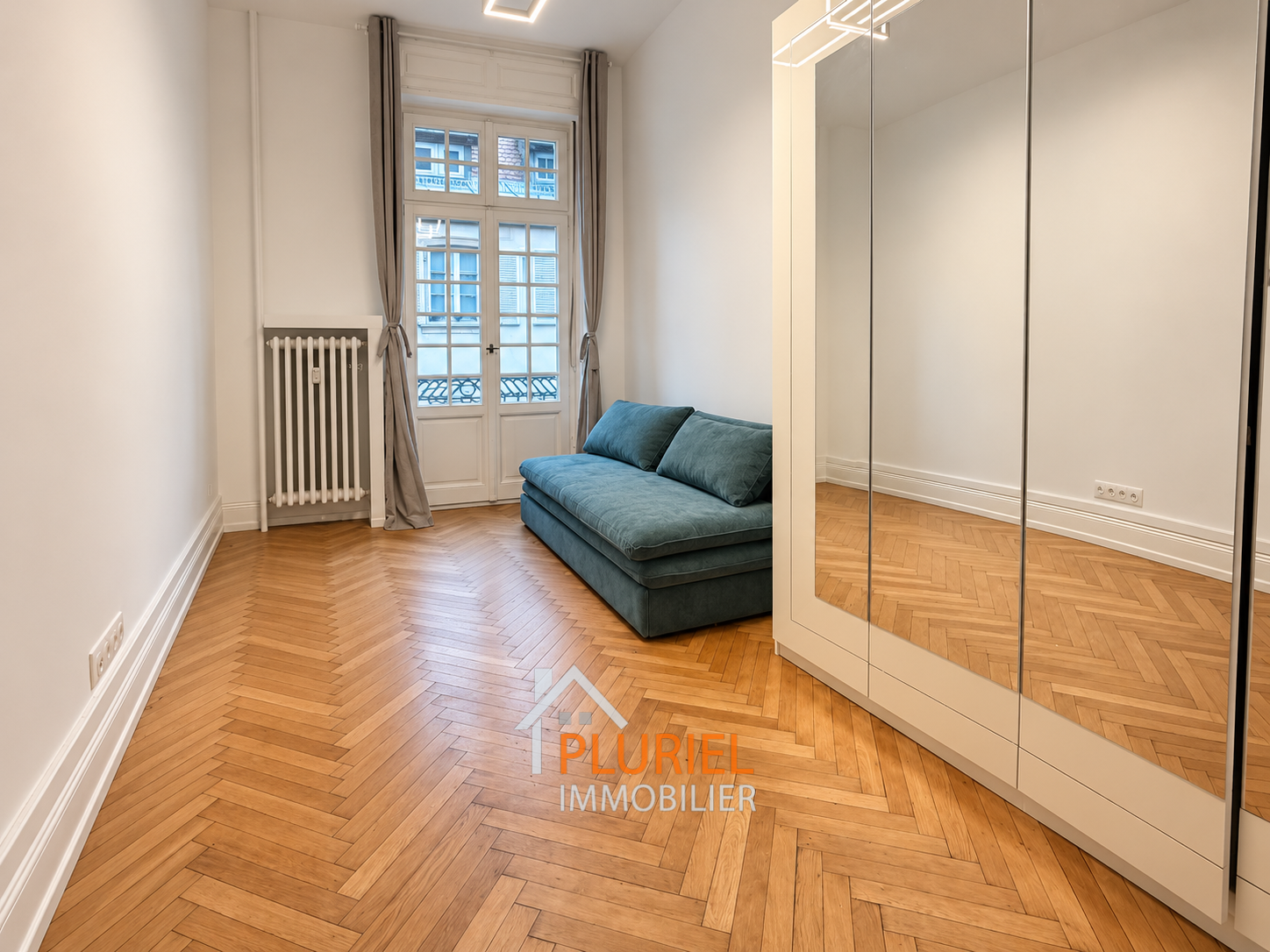 Salon minimaliste avec canapé bleu pétrole