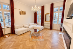 Salon parisien élégant avec canapé crème et parquet haugesund